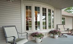 two chairs on the front porch with flowers