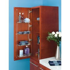 a bathroom cabinet with three shelves holding toiletries