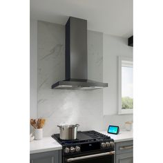 a stove top oven sitting inside of a kitchen next to a wall mounted range hood