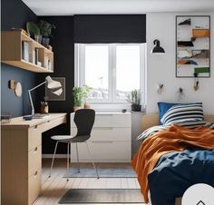 a bed room with a neatly made bed next to a desk and a computer monitor