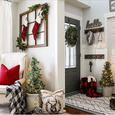 a living room decorated for christmas with stockings and wreaths hanging on the wall, potted trees