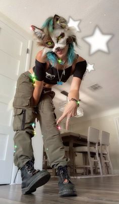 a woman with green hair and cat makeup is posing on the floor in front of a door