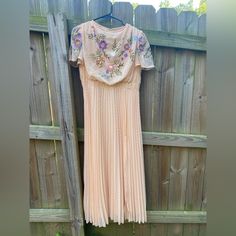 This Dress Is Beautiful. I Bought It To Wear To My Goddaughter’s Wedding But All Of Her Bridesmaids Were In Florals. It Is A Light Peachy Color With Gorgeous Embroidered Flowers. It Has Butterfly Sleeves, A Full Peach Lining With A Sheer Overlay. The Bodice Is Embroidered And Cowl Neck With A Pleated Skirt. Measurements: Arm Pit To Arm Pit: 18”, Shoulder To Hemline 53”, Front Waistline: 15”. Peach Party Dress With Floral Embroidery, Embroidered Peach Dress For Party, Fitted Peach Dress With Floral Embroidery, Fitted Peach Dress For Wedding, Vintage Peach Short Sleeve Dress, Peach Spring Wedding Dress, Vintage Fitted Apricot Dress, Fitted Vintage Apricot Dress, Apricot Fitted Vintage Dresses