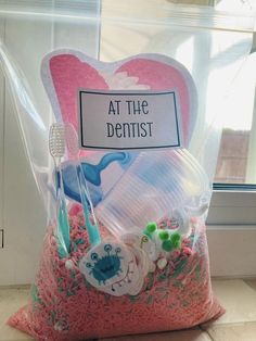 a toothbrush and toothpaste in a bag with the words at the dentist on it