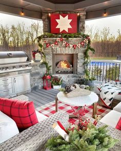 an outdoor patio decorated for christmas with red and white plaid tablecloths, pillows, and fireplace