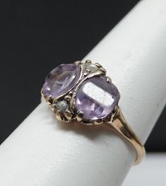 certainly one of the prettiest antiques i have seen. 2 panel cut amethyst , and very pale lavender for amethyst. Both are perfectly matched and about 1ct each. Has an accent seed pearl at the top and bottom. Petite ring , 11mm's north-south. This has been sized and the markings are lost. Tests 14K and in remarkable antique condition. 1.53 dwt. Purple Amethyst Ring Stamped 14k, Heirloom Purple Ring With Rose Cut Diamonds, Antique Oval Purple Amethyst Ring, Antique Purple Amethyst Ring With Accent Stones, Antique Oval Amethyst Ring, Vintage Purple Amethyst Ring For Anniversary, Purple Amethyst Ring With Rose Cut Diamonds For Wedding, Purple Amethyst Ring With Rose Cut Diamonds, Victorian Amethyst Ring In Yellow Gold