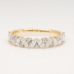 a yellow gold ring with five pear shaped diamonds