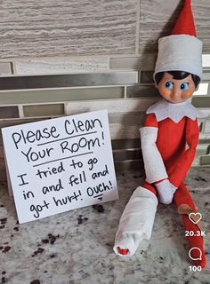 an elf is sitting next to a sign that says please clean your room i tried to go in and fell and got hurt out