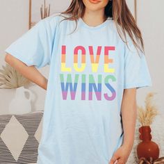 Love Wins Graphic Tee - Limeberry Designs Fun Blue T-shirt With Slogan, Relaxed Fit Crew Neck T-shirt For Pride, Fun Blue Tops With Slogan, Blue Graphic Tee With Lettering, Blue Relaxed Fit Tops With Lettering, Pride Graphic Print Crew Neck Top, Blue Short Sleeve T-shirt With Lettering, Blue Graphic Tee With Slogan, Blue Graphic Tee T-shirt With Slogan