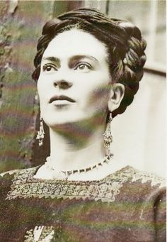 an old black and white photo of a woman with earrings on her head, looking off to the side