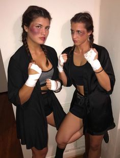 two beautiful women standing next to each other wearing boxing gloves