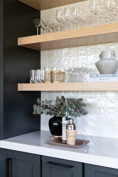 the shelves in this kitchen are filled with wine glasses and champagne flutes, along with other glassware