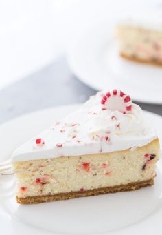 a slice of cheesecake with white frosting and sprinkles on top