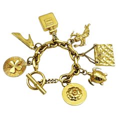 Chanel's gold-tone chain link bracelet with seven iconic Chanel items hung from the chain such as a shamrock, heels, a perfume bottle, cupid, a quilted Chanel bag and a turtle, a camellia, Coco Chanel's favorite flower! All iconic charms are almost identical on both sides and 24k gold plated. Measurement: The bracelet has a length of 20 cm, Size of the charms, the quilted pocket 3.5 x 2.5 cm, perfume bottle 3.5 x 2.5 cm, camelliar 3 cm, locking ring 2 cm, toggle 3.5 cm Features: - Material solid and gilded, - Signed 'CHANEL' on the clasp ring through which the toggle is inserted. - 7 iconic Chanel charms. - Excellent vintage condition - Chanel Charm Bracelet, Chanel Charms, 1980s Chanel, Chanel Charm, Quilted Pocket, Chanel Pendant, Chanel Items, Lucky Charm Bracelet, Charm Ideas