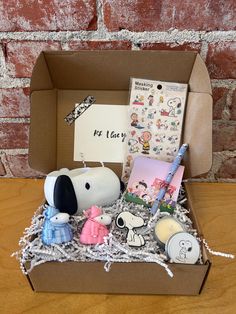 a box filled with assorted items sitting on top of a wooden table