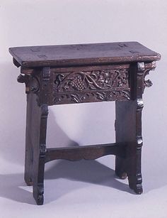 an old wooden table with carvings on the top and bottom, against a white background