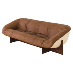 a brown and white couch sitting on top of a wooden frame