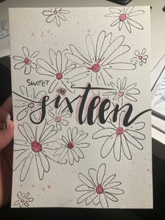 someone holding up a card with the word sweet sixteen written on it in black ink