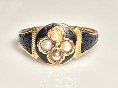 Lovely antique black enamel seed pearl momento mori ring ring in 15K yellow gold from the Victorian era. This beautiful ring has it's original Victorian 188(4?) hand engraving, full British assay marks for 1881 and original makers mark. In excellent condition with decorative floral repousee' covered with black enamel, as was traditional during the time. Four natural seed pearls in the middle. The top of the ring measures 9.7mm at its the center. The diameter of the circle area on top is 9.7mm. M Vintage Gold Enamel Ring Stamped 14k, Black Heirloom Jewelry For Ceremonial Occasions, Black Heirloom Ceremonial Jewelry, Black Heirloom Jewelry For Ceremonial Use, Black Enamel Ring For Wedding, Black Enamel Jewelry For Wedding, Black Enamel Wedding Jewelry, Antique Yellow Gold Signet Ring With Black Enamel, Victorian Oval Yellow Gold Enamel Ring