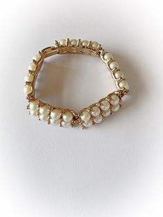 "Pretty vintage faux pearl link bracelet! 5 links with 8 pearls on each link in 2 rows. Has a flip style latch. Overall good/fair condition. Metal is free of rust and verdigris. There is minor to moderate wear to the gold tone finish. Minor wear to the \"pearls\". No makers mark. End to end measures 7 and 3/8 inches and 5/8 of an inch wide. Discounts offered for bulk purchases. Shop accepts PayPal, credit cards, Etsy gift cards, and postal money orders. ♥Check out the rest of the shop♥ https://w Classic Metal Pearl Bracelet For Formal Occasions, Vintage Pearl Bracelet For Formal Occasions, Vintage Pearl Bracelets For Parties, Vintage Pearl Beaded Bracelet, Vintage Gold Pearl Bracelets, Vintage Gold Pearl Bracelet For Formal Occasions, Vintage Adjustable Pearl Bracelet With Metal, Vintage Adjustable Metal Pearl Bracelet, Vintage Formal Pearl Bracelet