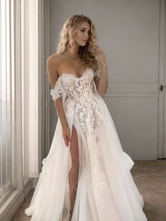 a woman in a white wedding dress posing with her leg up on the floor and wearing high heels