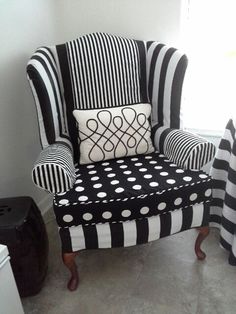 a black and white striped chair with polka dots on the seat, next to a window