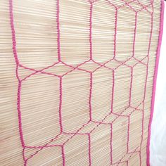 the wall is made out of bamboo and has pink trimmings on it's edges