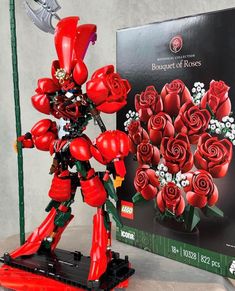 a red robot with flowers in front of a box