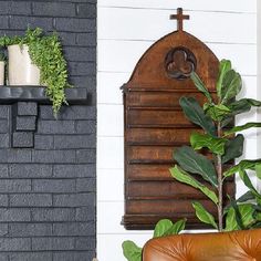 a brown leather chair sitting in front of a brick wall with plants on the shelves