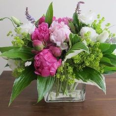 a glass vase filled with pink and white flowers