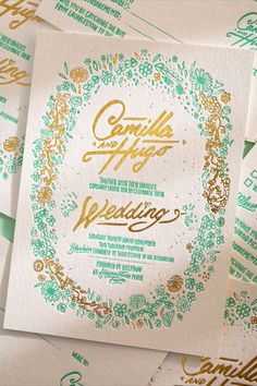 some white and green wedding cards with gold lettering