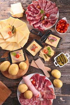 several different types of cheeses and meats are arranged on the table with other food items