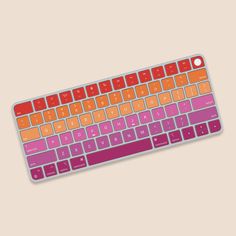 an orange and pink keyboard on a white surface with the keys turned to different colors