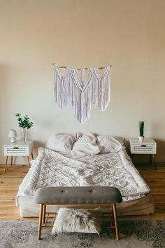 a bed with white sheets and pillows in a room