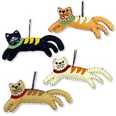 three cat ornaments hanging from clothes pins on a white background, one is orange and the other is black