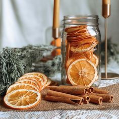 an orange cut in half sitting next to some cinnamons and spices on a table