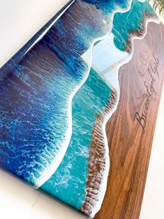 a beach scene with waves crashing on the shore and a wooden plaque that reads, happy birthday