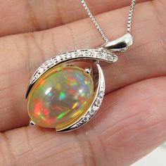 Fine hand-crafted solid platinum (Pt.900) pendant with 0.07ctw. of sparkling natural mined accent diamonds and a large 3.676ct. of  Ethiopian flashy 'harlequin", untreated "fire opal". So striking rolling flashed of rainbow colors (red, green, blue, orange gold; etc.). The necklace is also made of platinum (stamped: Pt850).  It is fine, dainty necklace, which about 0.7mm in thickness & 17.5 inches in length and can be adjust to shorten it. Style: Pendant Necklace Precious Metal: Solid Platinum (PT900) Genuine diamond: 0.07ctw. Pendant Size (L x W):  13.5mm x 25.8mm Necklace Length: 17.5 inches & adjustable. Total Weight (includes chain): 8.7 grams. Opal Type: Welo Opal. Size: 9.5 x 13.8mm Weight: 3.676ct. Color:   Beautiful array of color spectrum. Treatment: Natural (untreated). Origin: E Platinum Pendant Necklaces As Gift, Platinum Pendant Necklace For Gift, Polished Platinum Necklace As A Gift, Platinum Necklaces With Polished Finish As A Gift, Platinum Oval Necklace For Gifting, Platinum Oval Necklace As Gift, Platinum Oval Necklaces For Gifts, Platinum Oval Necklace For Gift, Silver Diamond Jewelry With Bail