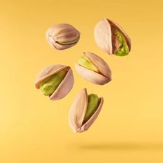 pistachios falling into the air on a yellow background