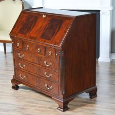 an old wooden desk with two chairs in the background