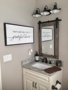 a bathroom with a sink and mirror next to a framed sign that says start each day with a grateful heart