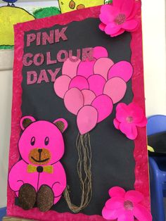 a pink and black sign with balloons attached to it