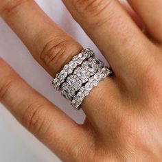 a woman's hand with a diamond ring on top of her finger and an engagement band