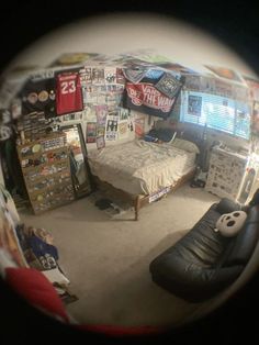 a bedroom with a bed, desk and television in it's reflection through a fish eye lens