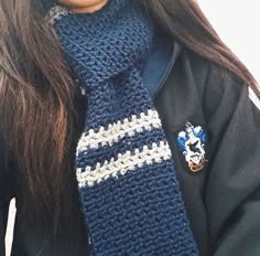 a close up of a person wearing a knitted tie with a badge on it