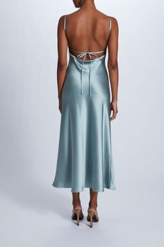 the back of a woman wearing a light blue satin slip on top of her dress