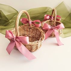 two wicker baskets with pink bows and ribbons