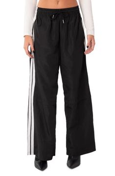 Sporty stripes trail the sides of these wide-leg track pants topped with a comfortable elastic waist. 100% polyester Machine wash, tumble dry Imported Sporty Wide Leg Pants With Elastic Waistband For Streetwear, Sporty Wide Leg Pants For Streetwear, Sporty Black Wide Leg Pants, Sports Wide Leg Pants With Three Stripes, Black Wide Leg Athleisure Pants, Sporty Wide Leg Pants With Three Stripes, Wide Leg Sports Pants With Three Stripes, Sporty Wide Leg Pants With Elastic Waistband, Relaxed Fit Sports Pants With Contrast Stripes