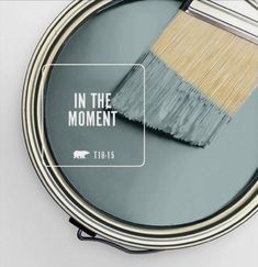 a paint brush with the words in the moment above it on top of a can