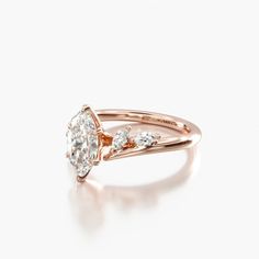 a rose gold engagement ring with three pear shaped diamonds